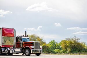 Red semi truck with forest in background