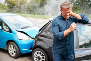 Man holds his neck after rear-end car wreck